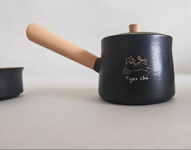 TigerCha teapot product photo with a wooden handle and laser logo.
